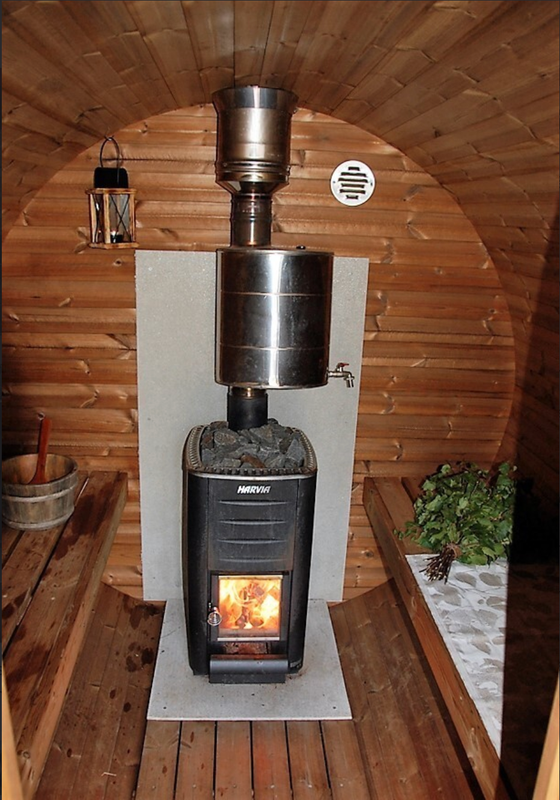 Ultimate tynnyrisauna on sis&auml;lt&auml; viihtyis&auml; ja tilava. Kuvassa kiuas lasiluukulla ja hormi vedenl&auml;mmittimen kanssa (CE-sertifioitu). Toimituksessa vakiona Vilpran Magna kiuas ja hormi, jonka saa lis&auml;tilauksena mattamustana.